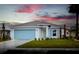 New single-story home with light blue garage door and landscaping at 573 Rose Apple Cir, Port Charlotte, FL 33954