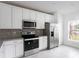 Modern kitchen with gray countertops, white cabinets, and stainless steel appliances at 573 Rose Apple Cir, Port Charlotte, FL 33954