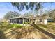 Ranch-style home, screened porch, and lush landscaping at 708 Buena Vista Ave, Brooksville, FL 34601