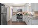 Kitchen with white cabinets, stainless steel appliances, and wood-look floors at 708 Buena Vista Ave, Brooksville, FL 34601