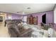 Living room with purple walls, brown furniture, and a large TV at 804 67Th W St, Bradenton, FL 34209