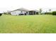 Large grassy backyard with a view of the home and screened patio at 8203 Abalone Loop, Parrish, FL 34219