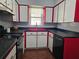 Retro kitchen features red cabinets, black countertops, and classic appliances at 908 N Gordon St, Plant City, FL 33563