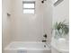 Tiled shower and tub with black hardware, and a decorative fern near the toilet at 979 11Th S Ave, St Petersburg, FL 33705