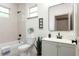 Bright bathroom featuring a gray vanity, black hardware, large mirror, tiled shower/tub, and stylish decor at 979 11Th S Ave, St Petersburg, FL 33705