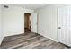 Bedroom with wood-look floors, open door to hallway, and two closets at 962 James S Ave, St Petersburg, FL 33705