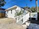 Rear exterior view of a charming home with white siding, wooden deck and stepping stone landscaping at 979 11Th S Ave, St Petersburg, FL 33705