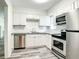 Well-lit kitchen boasts stainless steel appliances, granite countertops and white cabinets at 979 11Th S Ave, St Petersburg, FL 33705
