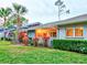 Gray condo with red door, walkway, landscaping, and palm trees at dusk at 10 Aster Pl, Oldsmar, FL 34677