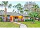 Gray condo with red door, walkway, landscaping, and palm trees at dusk at 10 Aster Pl, Oldsmar, FL 34677