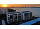 Aerial view of waterfront condo building at sunset at 100 Oakmont Ln # 309, Belleair, FL 33756