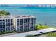 Aerial view of waterfront building with parking and water access at 100 Oakmont Ln # 309, Belleair, FL 33756