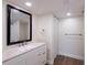 White vanity with quartz countertop, black framed mirror, and wood-look floors at 100 Oakmont Ln # 309, Belleair, FL 33756
