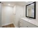 Bathroom with white vanity, quartz countertop, and black framed mirror at 100 Oakmont Ln # 309, Belleair, FL 33756