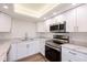 Modern white kitchen with stainless steel appliances at 100 Oakmont Ln # 309, Belleair, FL 33756