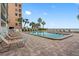 Community pool with lounge chairs and ocean views at 12924 Gulf Blvd # 307, Madeira Beach, FL 33708