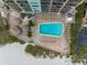 Aerial view of refreshing pool, spacious deck with lounge chairs, and beach access at 12924 Gulf Blvd # 307, Madeira Beach, FL 33708