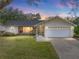 Single-story home with a large yard and attached garage at 1559 Glengarry Dr, Palm Harbor, FL 34684