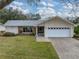 House exterior with a two-car garage and landscaping at 1559 Glengarry Dr, Palm Harbor, FL 34684