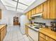 Kitchen with wood cabinets, white appliances, and tile floor at 1559 Glengarry Dr, Palm Harbor, FL 34684