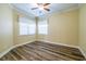 Well-lit bedroom with ceiling fan and wood-look floors at 16122 Cedar Key Dr, Wimauma, FL 33598