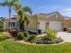 Tan house with a two-car garage and well-manicured landscaping at 16122 Cedar Key Dr, Wimauma, FL 33598