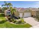 Tan house with a two-car garage and well-manicured landscaping at 16122 Cedar Key Dr, Wimauma, FL 33598