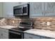 Kitchen detail showcasing stainless steel appliances and stylish backsplash at 16122 Cedar Key Dr, Wimauma, FL 33598