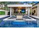 Luxury pool with built-in seating and fire pit; adjacent outdoor kitchen and patio at 16220 Villarreal De Avila, Tampa, FL 33613