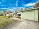 Charming single-story home with a light green garage and well-maintained lawn at 1825 San Mateo Dr, Dunedin, FL 34698