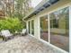Relaxing patio with tiled flooring and wicker chairs, adjacent to the house at 1825 San Mateo Dr, Dunedin, FL 34698