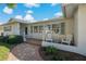 Inviting front porch with brick walkway and white chairs at 2211 Morningside Dr, Clearwater, FL 33764