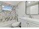Updated bathroom with marble-look tile and a white vanity at 3020 Deleuil Ave, Tampa, FL 33610