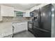 Modern kitchen with white cabinets, granite counters, and black appliances at 3020 Deleuil Ave, Tampa, FL 33610