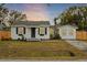 Charming bungalow with a white exterior, landscaped lawn, and fenced yard at 3111 Bay Ln, Clearwater, FL 33759