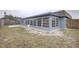 Backyard view showcasing a Florida room addition and concrete patio at 3205 Moog Rd, Holiday, FL 34691