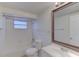 White bathroom featuring a vanity sink, toilet, a tub with subway tile and a window at 3205 Moog Rd, Holiday, FL 34691