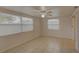 Cozy bedroom featuring tile floors, bright windows, and a ceiling fan at 3205 Moog Rd, Holiday, FL 34691