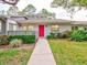 Front view of the house, showcasing the red door and landscaping at 40 Aster Pl, Oldsmar, FL 34677