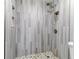 Modern shower with gray tile walls and pebble floor at 40 Aster Pl, Oldsmar, FL 34677