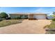 Tan single-story home with a large driveway and mature landscaping at 495 Bath Club N Blvd, North Redington Beach, FL 33708