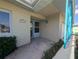 Front door entry with teal accents and a paved walkway at 495 Bath Club N Blvd, North Redington Beach, FL 33708