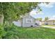 Gray house nestled amongst lush greenery, featuring a white fence at 6108 Pershing Ne St, St Petersburg, FL 33703