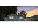 Charming gray house with a stone base, white fence, and a landscaped yard at 6108 Pershing Ne St, St Petersburg, FL 33703