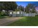 Gray house with a stone base, white fence, and well-maintained lawn at 6108 Pershing Ne St, St Petersburg, FL 33703