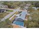 An aerial view showcasing a house with a solar panel system and a screened-in pool at 7101 69Th N St, Pinellas Park, FL 33781