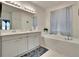Elegant bathroom with double vanity, soaking tub, and tiled flooring at 7102 Wesley Palm Way, Wesley Chapel, FL 33545