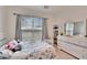 Bright bedroom with floral bedding, window, and dresser at 7102 Wesley Palm Way, Wesley Chapel, FL 33545