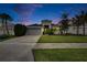 Single-story home with gray exterior, two-car garage, and manicured lawn at 7102 Wesley Palm Way, Wesley Chapel, FL 33545