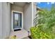 Modern teal front door with glass accents and welcoming walkway at 7102 Wesley Palm Way, Wesley Chapel, FL 33545